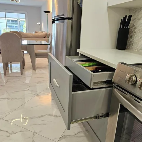a kitchen with granite countertop a sink stove and refrigerator