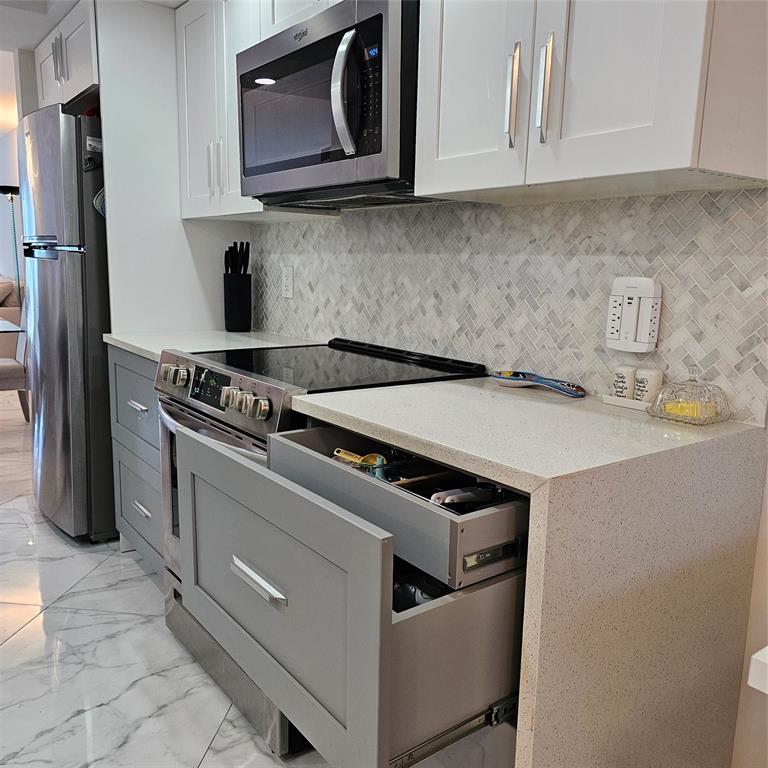 1705 Andros Isle, Unit C3 Coconut Creek, FL 33066 - Photo 28 of 36 a kitchen with granite countertop a sink stove and refrigerator