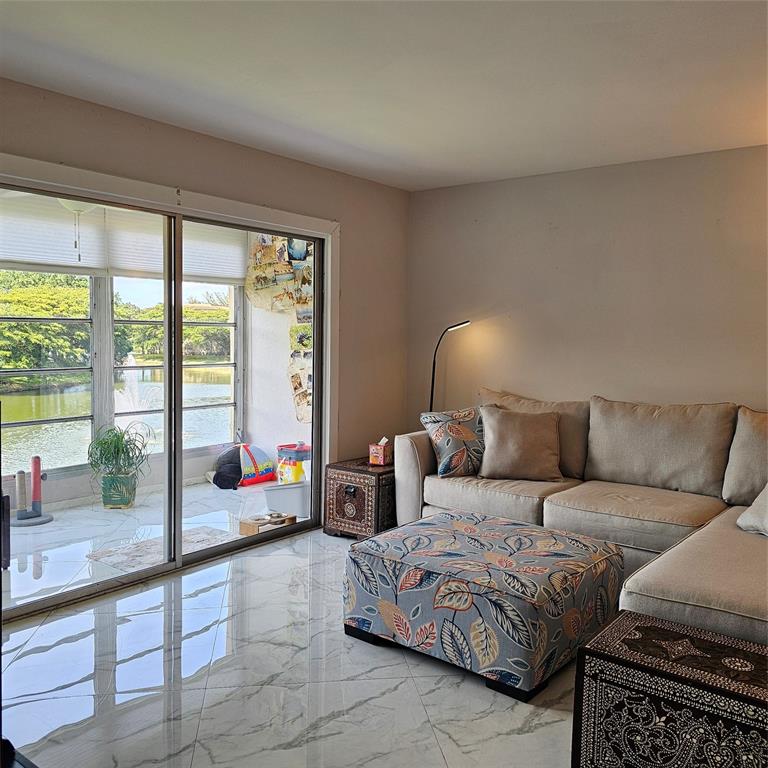 1705 Andros Isle, Unit C3 Coconut Creek, FL 33066 - Photo 6 of 36 a bedroom with a bed and glass window