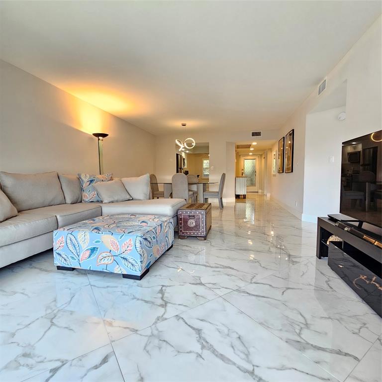 1705 Andros Isle, Unit C3 Coconut Creek, FL 33066 - Photo 9 of 36 a living room with furniture and a flat screen tv