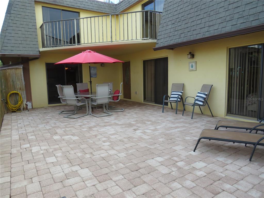 a view of a patio with a table and chairs under an umbrella