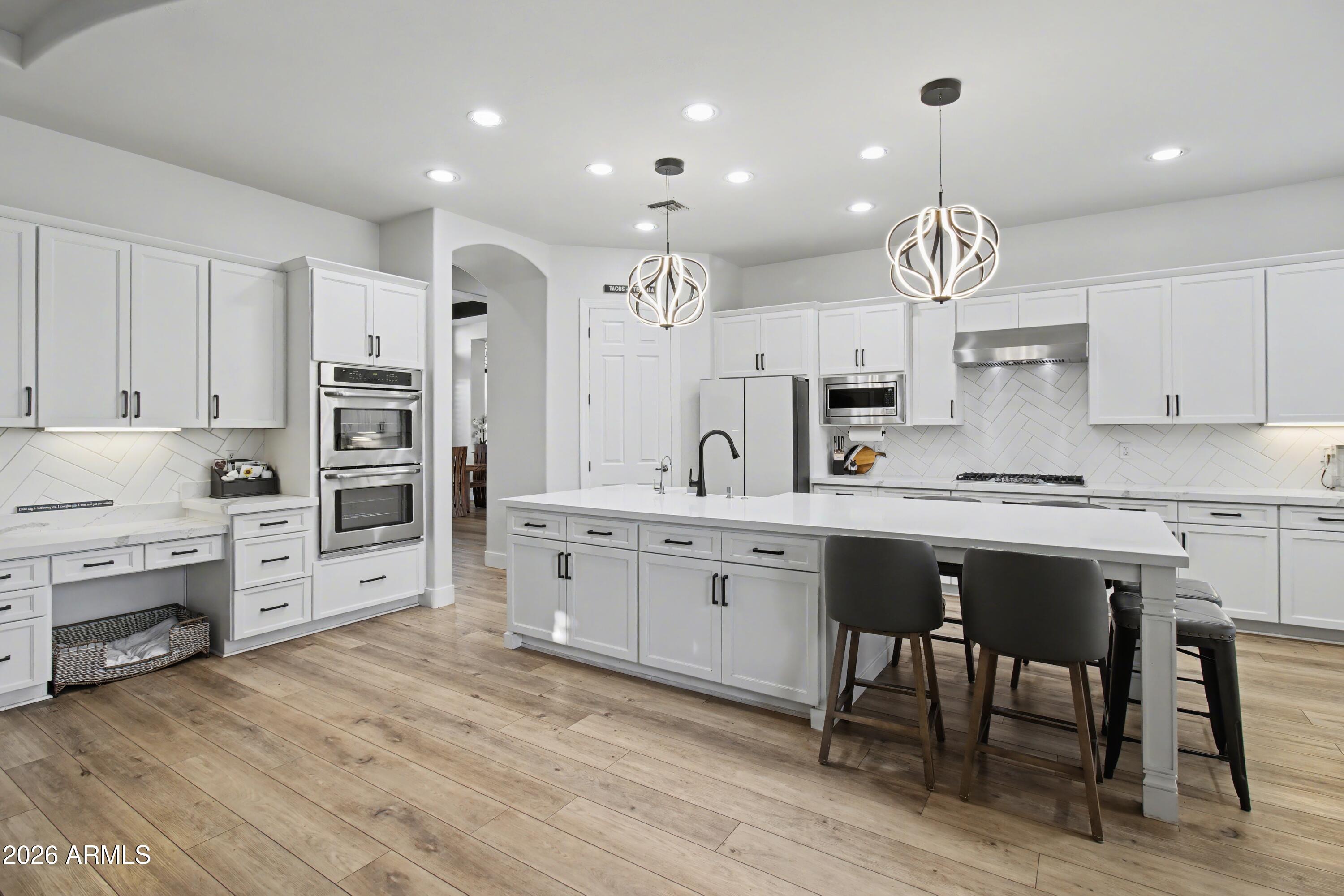 2184 West Weatherby Way Chandler, AZ 85286 - Photo 10 of 60 a large kitchen with cabinets chairs and wooden floor