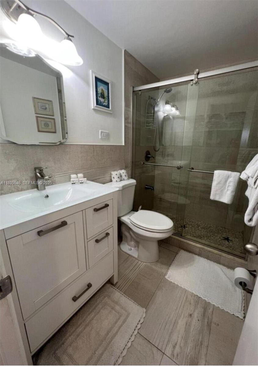 251 2nd Street Key Colony Beach, FL 33051 - Photo 9 of 20 a bathroom with a double vanity sink toilet and shower