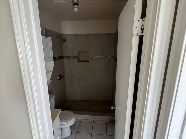 a bathroom with a granite countertop shower and a toilet