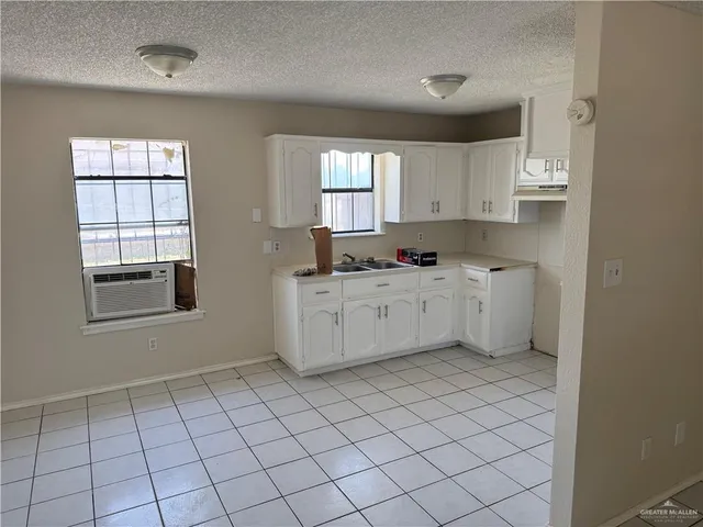 a kitchen with stainless steel appliances a sink window and cabinets