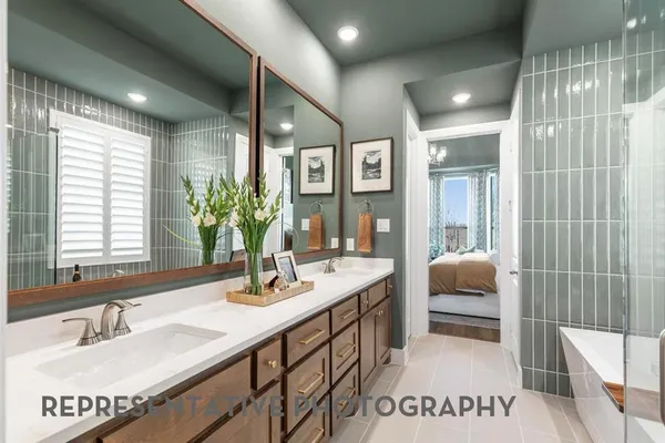 a bathroom with double vanity sinks a large mirror and a shower