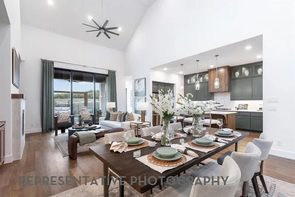 a living room with furniture kitchen view and a large window