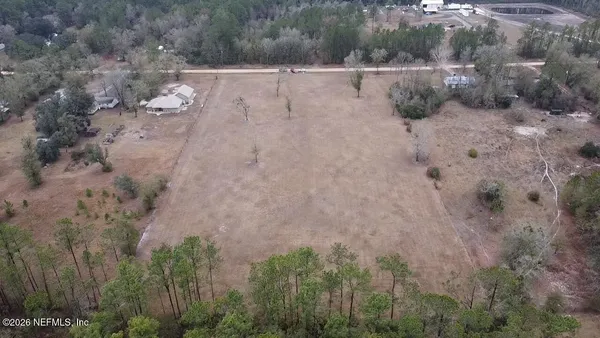 a view of a dry yard with trees