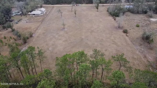 a view of a dry yard with trees