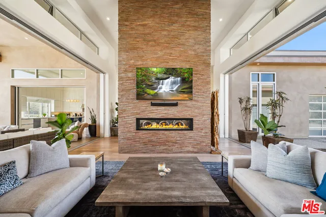 a large kitchen with kitchen island a large counter top stainless steel appliances and cabinets