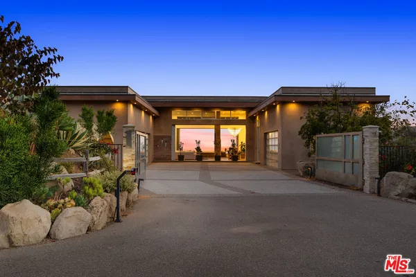 a dining room with furniture potted plants and wooden floor