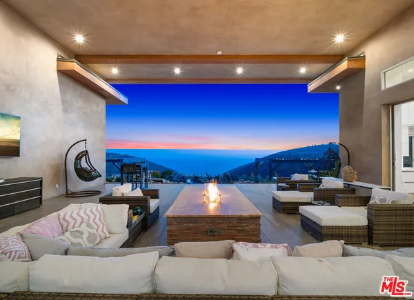 a living room with fireplace furniture and a large window