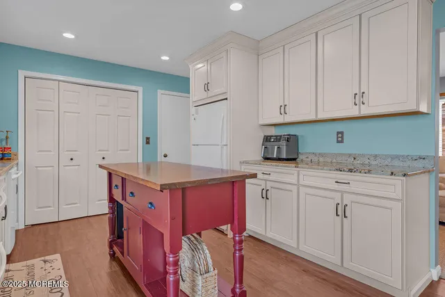 a kitchen that has a lot of cabinets in it and wooden floors