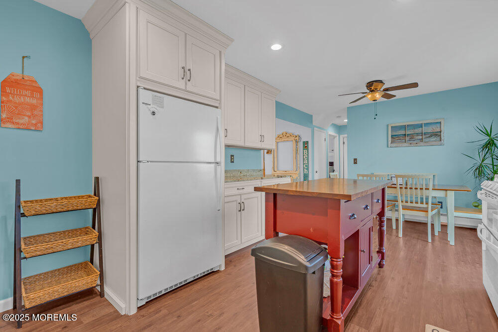 826 Forepeak Drive Forked River, NJ 08731 - Photo 13 of 56 a kitchen with stainless steel appliances granite countertop a refrigerator a stove a sink and a dining table with wooden floor
