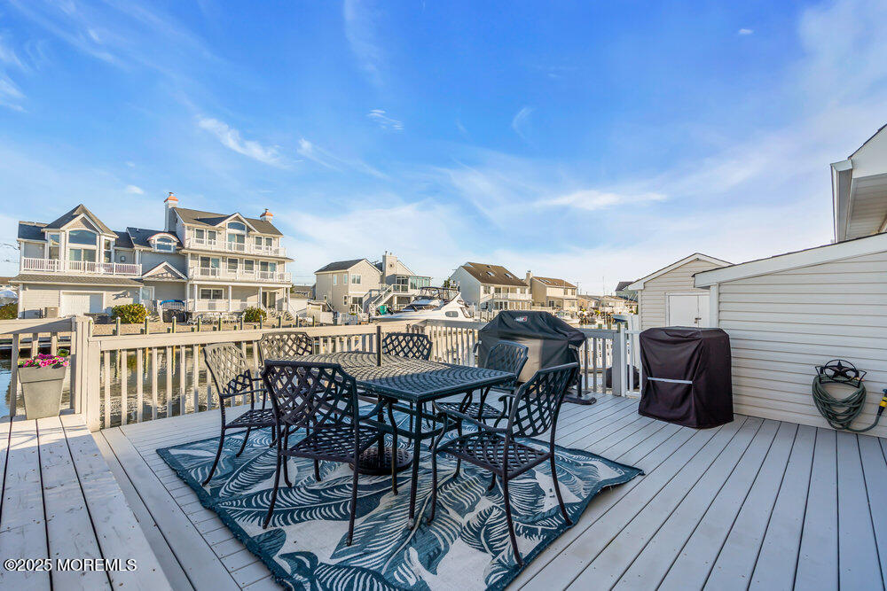826 Forepeak Drive Forked River, NJ 08731 - Photo 45 of 56 a view of a roof deck with table and chairs a barbeque with wooden floor and fence