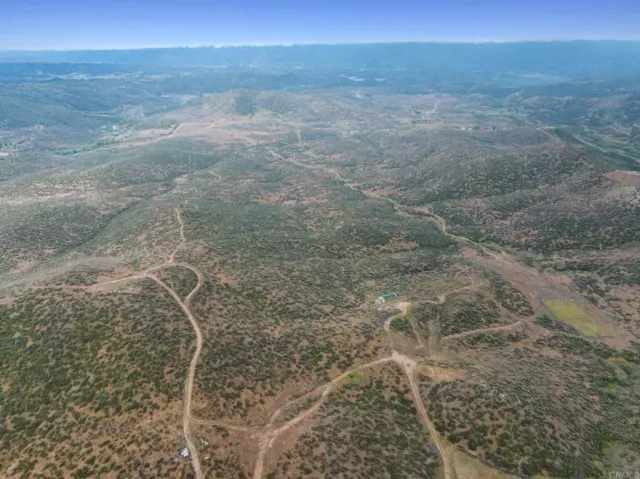 a view of a dry yard with mountains in the background