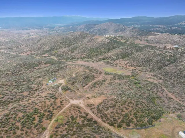 a view of a dry yard with mountains in the background