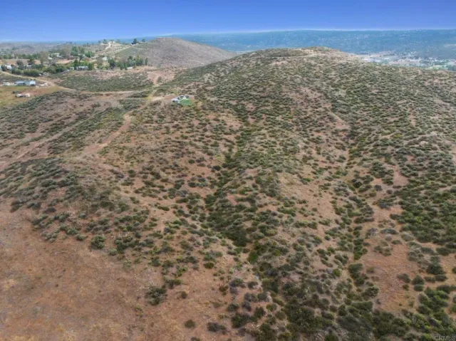 a view of a dry yard with mountains in the background
