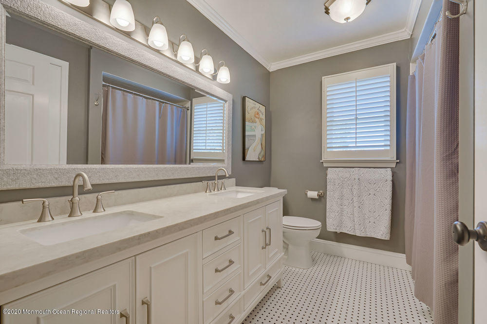 802 Wall Road Spring Lake Heights, NJ 07762 - Photo 19 of 27 a bathroom with a double vanity sink a toilet and a mirror
