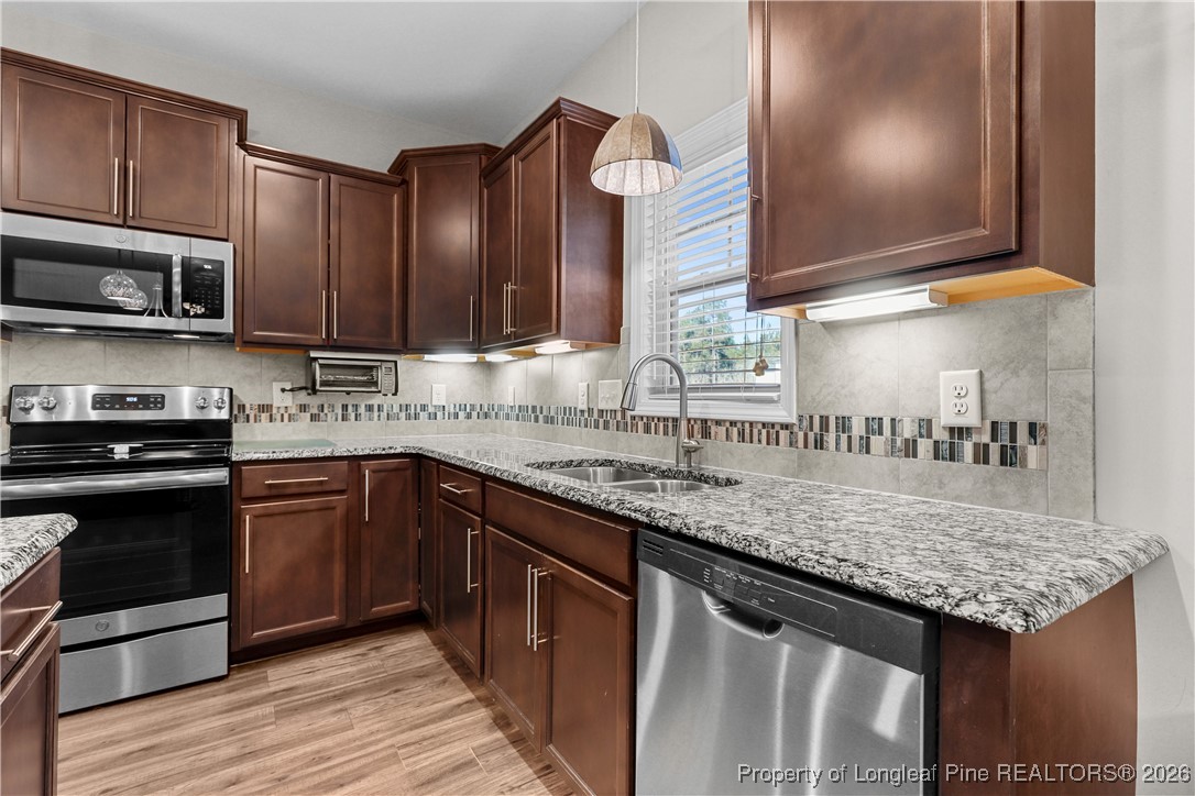 1908 Sweetfern Place Aberdeen, NC 28315 - Photo 12 of 46 a kitchen with stainless steel appliances granite countertop a sink and stove