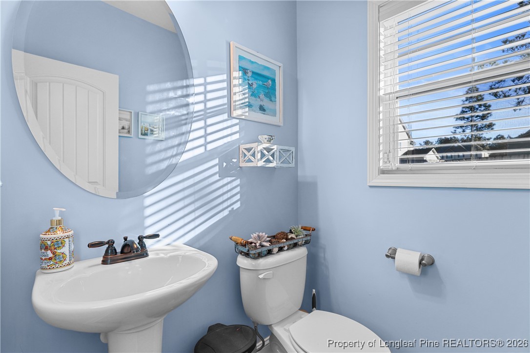 1908 Sweetfern Place Aberdeen, NC 28315 - Photo 15 of 46 a bathroom with a toilet a sink and a mirror