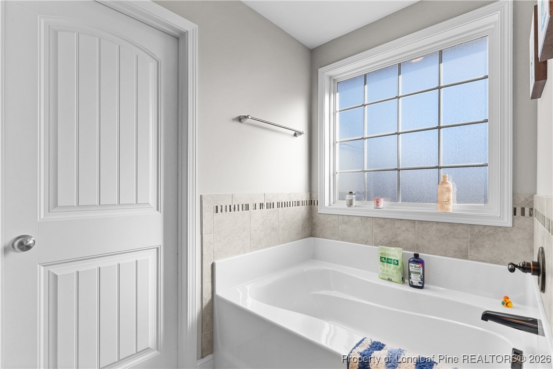 1908 Sweetfern Place Aberdeen, NC 28315 - Photo 22 of 46 a bathroom with bathtub a window and sink