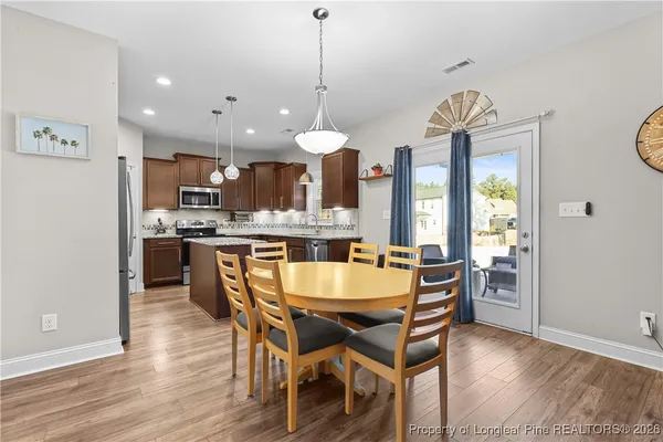 a dining room filled chandelier and wooden floor