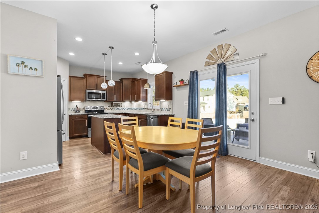 1908 Sweetfern Place Aberdeen, NC 28315 - Photo 8 of 46 a dining room filled chandelier and wooden floor