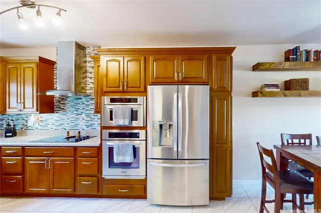 a kitchen with stainless steel appliances granite countertop a refrigerator and a stove top oven