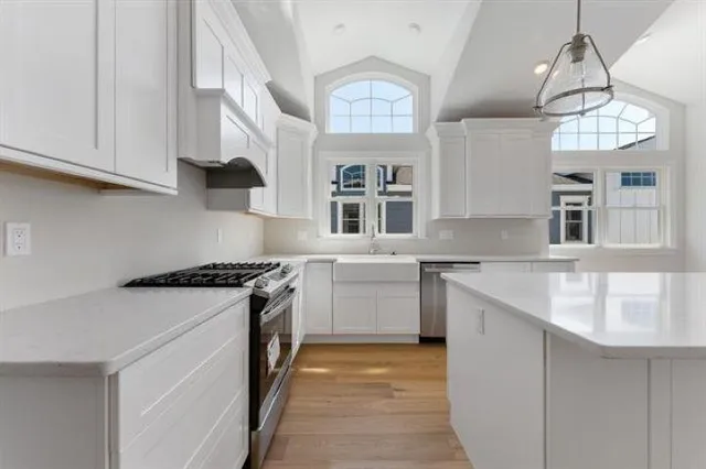 a kitchen with stainless steel appliances granite countertop a sink a stove and a refrigerator