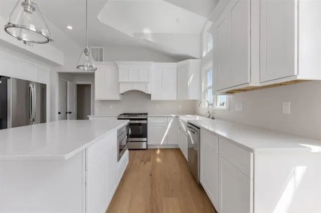 a kitchen with kitchen island a sink stove and refrigerator