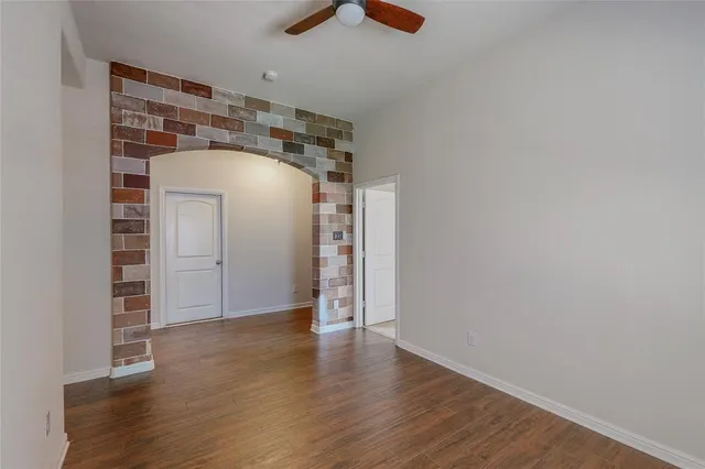 an empty room with wooden floor closet and chandelier fan