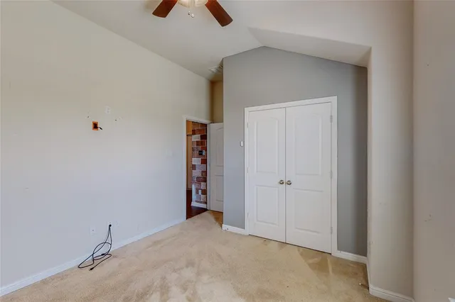 an empty room with closet and windows