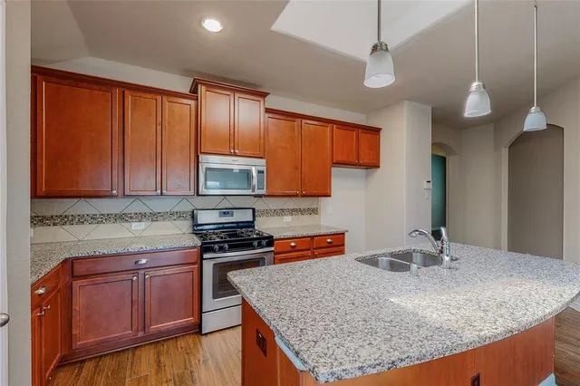 a kitchen with stainless steel appliances granite countertop a sink microwave and cabinets