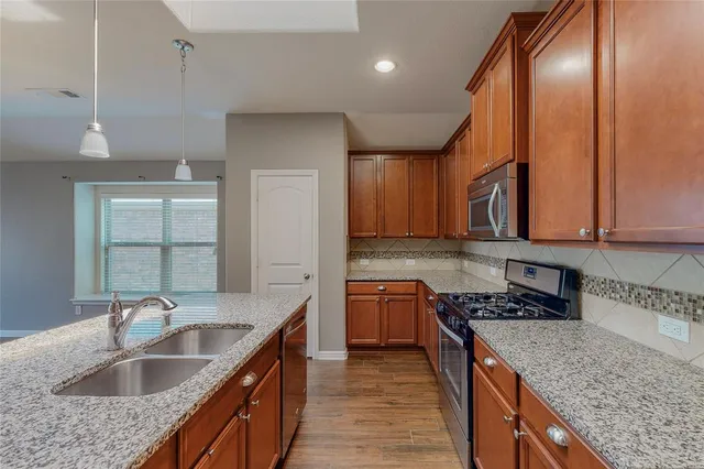 a kitchen with stainless steel appliances granite countertop a sink stove and cabinets