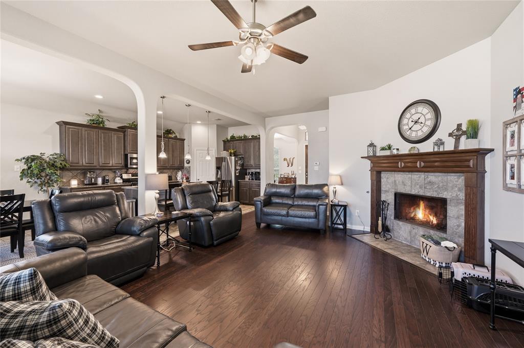 140 Chestnut Road Waxahachie, TX 75165 - Photo 9 of 26 Living area with dark wood-finish flooring, a ceiling fan, and a tiled fireplace featuring a wood mantel