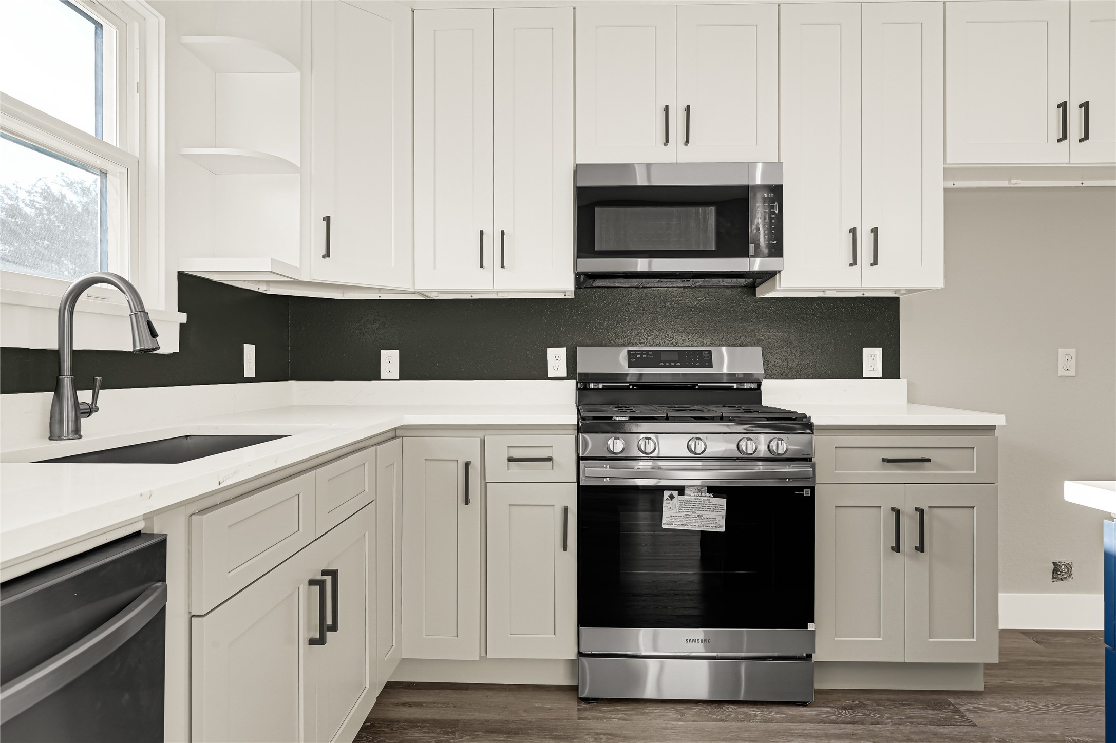 5930 Boness Road, Unit A & B Houston, TX 77396 - Photo 14 of 43 The kitchen features stainless steel appliances, including a range, microwave, and dishwasher.