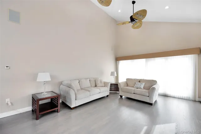 a living room with furniture and a ceiling fan