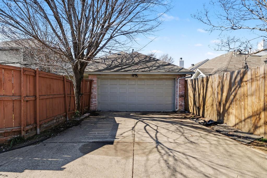 6921 Hominy Ridge Rowlett, TX 75089 - Photo 27 of 27 a view of a house with a large tree and wooden fence