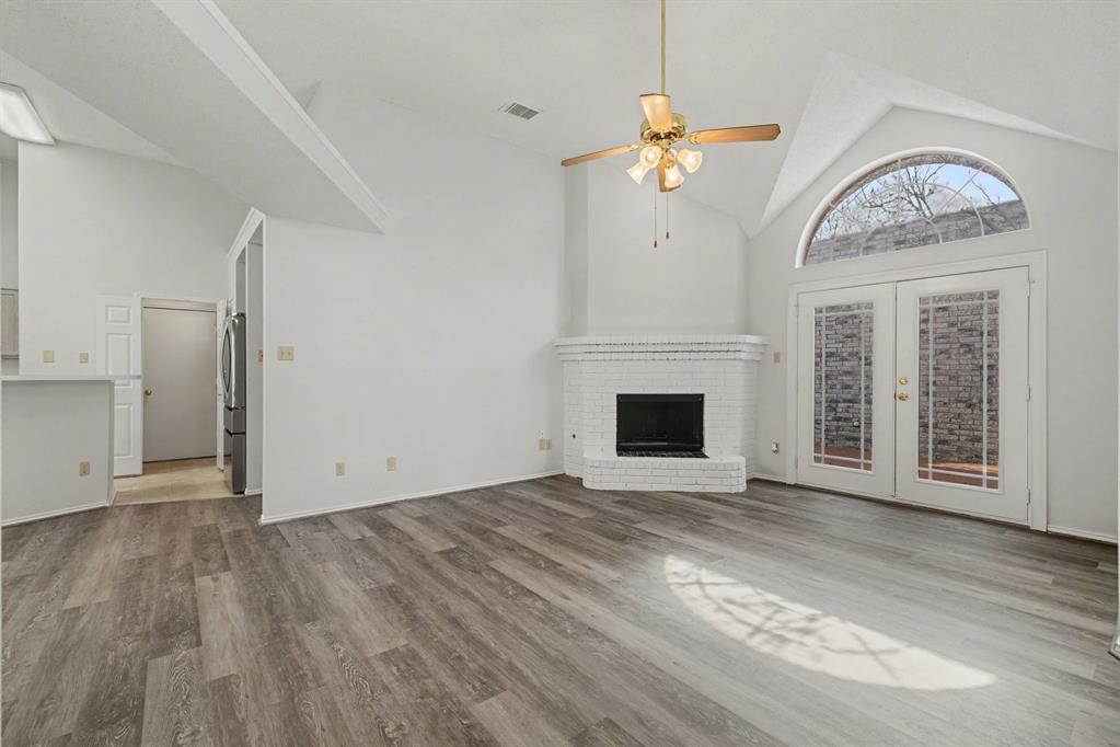 6921 Hominy Ridge Rowlett, TX 75089 - Photo 6 of 27 a view of a livingroom with a fireplace a chandelier and wooden floor