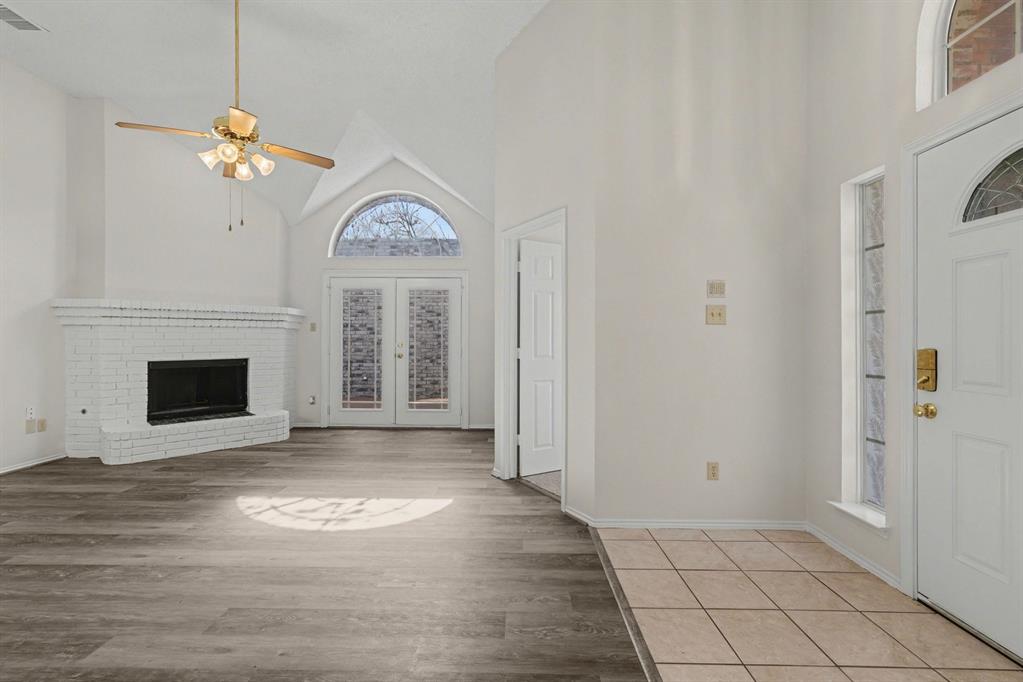 6921 Hominy Ridge Rowlett, TX 75089 - Photo 7 of 27 a view of a livingroom with a fireplace a ceiling fan and window