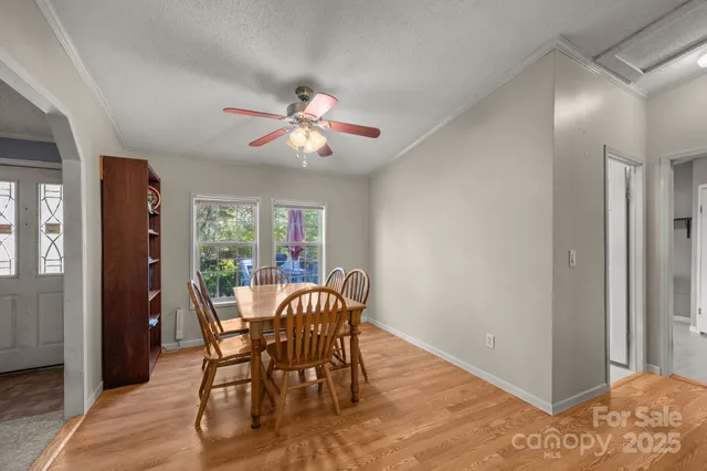 a kitchen with stainless steel appliances granite countertop a dining table chairs and a refrigerator