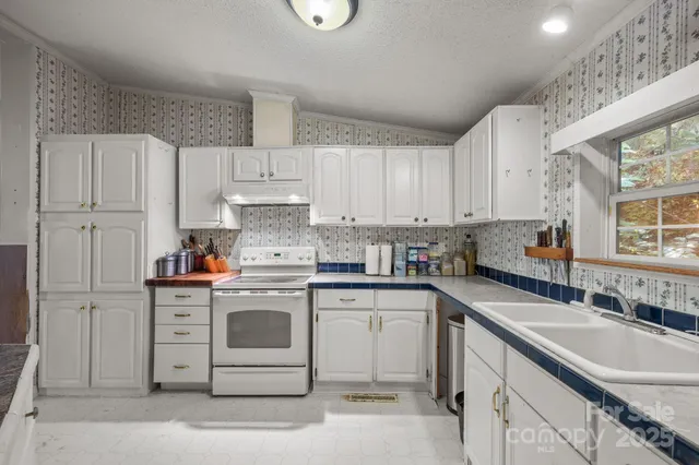 a kitchen with a stove cabinets and chairs