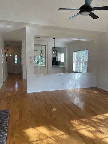 a view of a hallway with wooden floor and a chandelier
