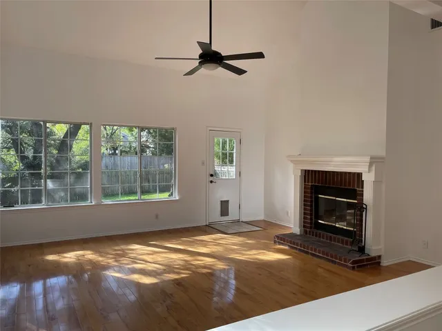 a view of an empty room with a fireplace and a window