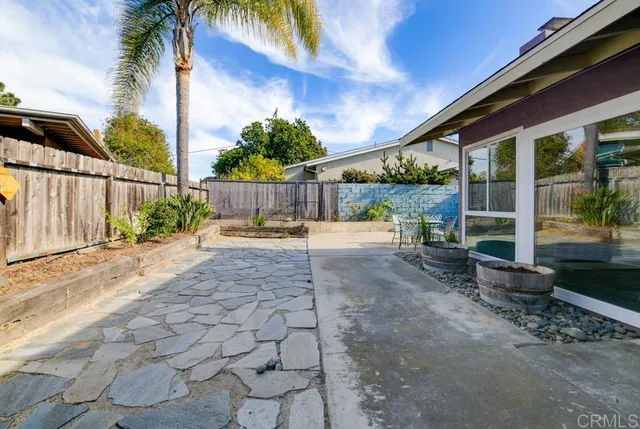 a view of a backyard with potted plants and large tree