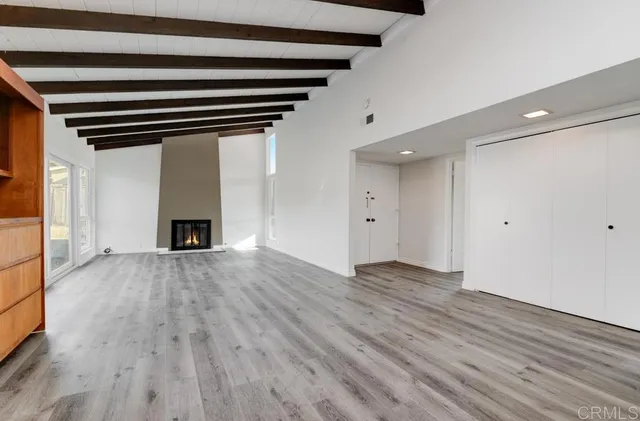 a view of empty room with wooden floor and fireplace