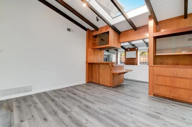 a view of empty room with wooden floor and cabinet