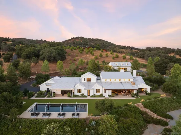 an aerial view of a house with a big yard and large trees