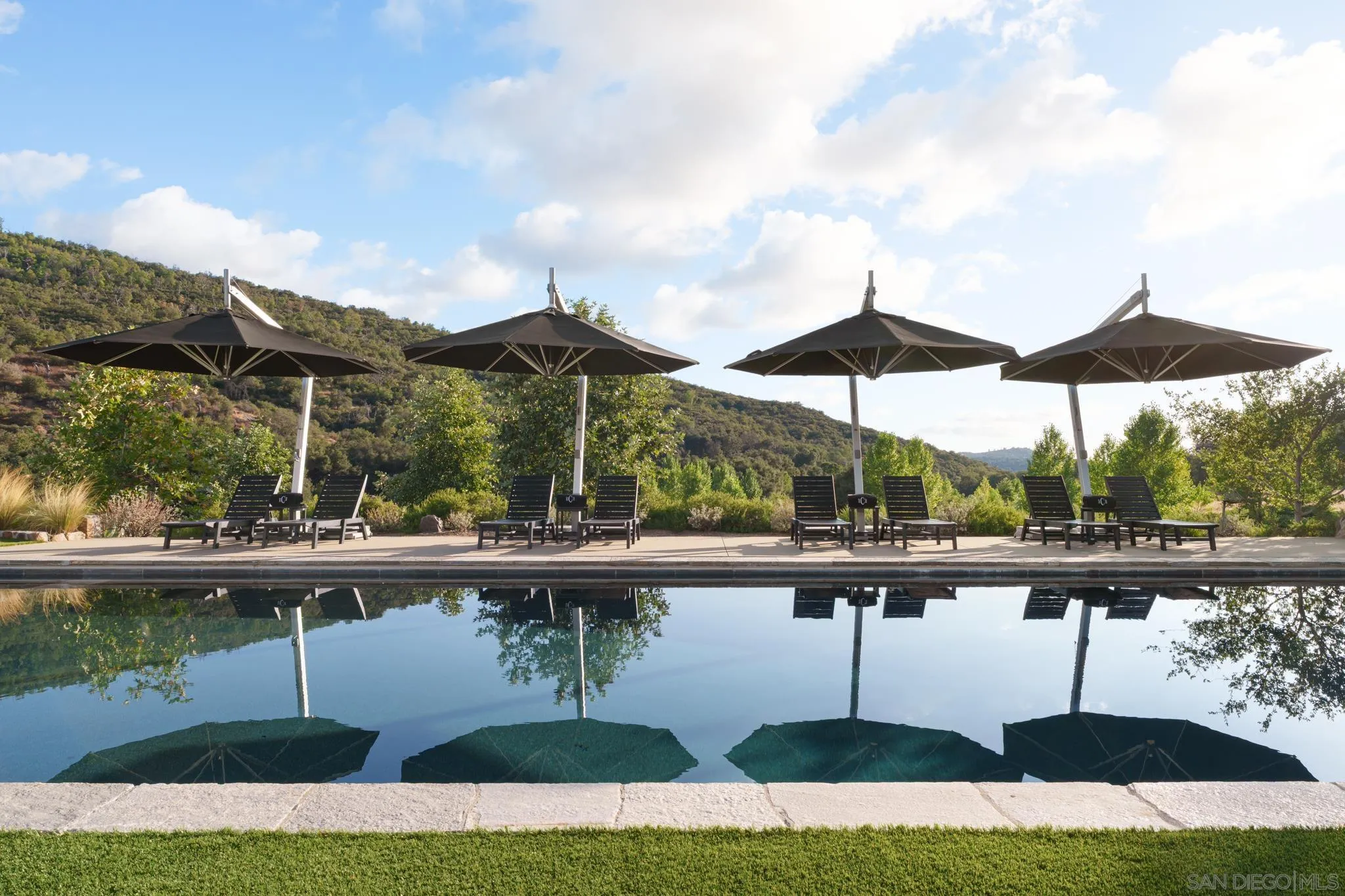 26904 Mesa Grande Road Santa Ysabel, CA 92070 - Photo 15 of 72 a view of swimming pool with lawn chairs under an umbrella